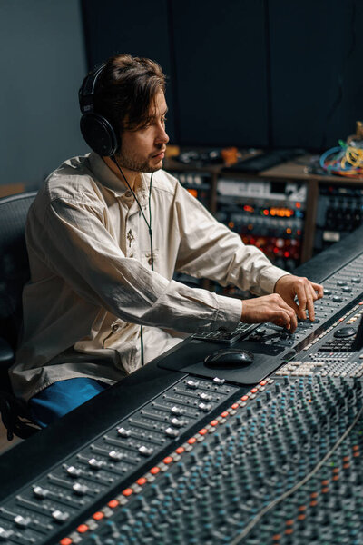 Звукоинженер, работающий в домашней музыкальной студии с мониторами и эквалайзером