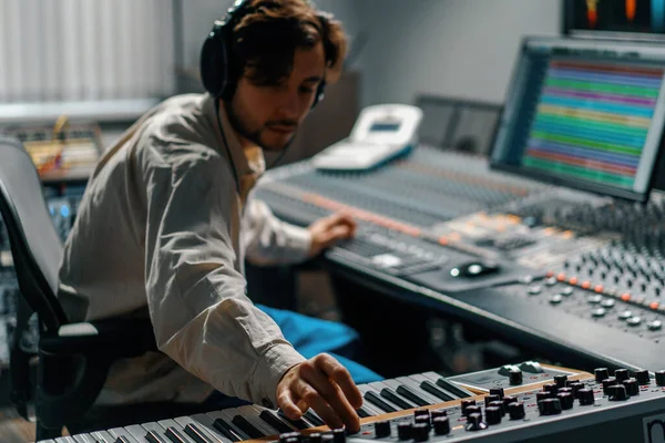 男性の手は電子ピアノキーボードを再生指はキーをタップしますミディコントローラーミュージシャンは録音スタジオで曲を生成します — ストック写真