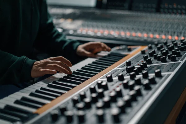 男性の手は電子ピアノキーボードを再生指はキーをタップしますミディコントローラーミュージシャンは録音スタジオで曲を生成します — ストック写真