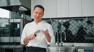 Profesyonel mutfak şefi kahvaltıdan sonra temiz bıçak temizler. Sağlıklı yemek kavramı.