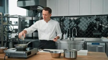 Profesyonel mutfak şefi karamelli meyveye pekmez ekliyor. Yulaf ezmesi için tavada kahvaltı hazırlıyor. Sağlıklı gıda kavramı.