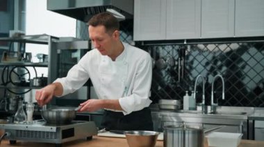 Profesyonel mutfak şefi tavada yulaf ezmesi için meyve karamelize ediyor kahvaltıda sağlıklı gıda konsepti hazırlıyor.