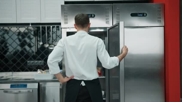 전문적 요리사가 냉장고를 살펴보고 요리에 재료를 — 비디오