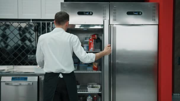 전문적 요리사가 냉장고를 살펴보고 요리에 재료를 — 비디오