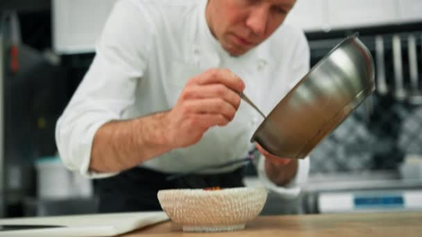 전문적 요리사가 오트밀 컨셉트에 캐러멜화 조각을 놓는다 — 비디오