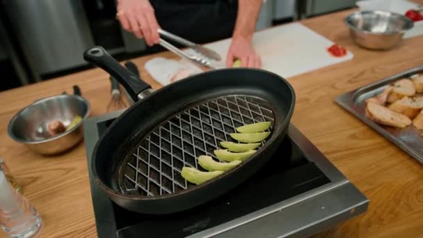 プロのキッチンシェフは フライパン野菜の上に新鮮な緑のアボカドをレイアウト健康的な食品コンセプト — ストック動画