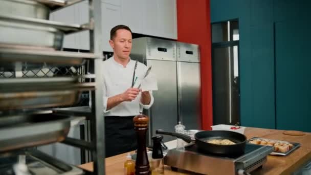 プロのキッチンシェフがタオルトングでワイプ調理器具調理コンセプト — ストック動画