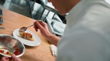 Profesyonel aşçı avokado ve domatesli tostu sağlıklı yemek kahvaltısı kavramının üzerine baharat döker.