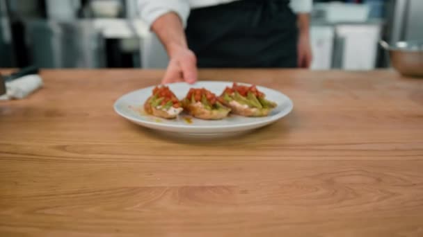 テーブルの上にアボカドとトマトで焼きたてのトーストを提供するプロのシェフ健康的な朝食コンセプト — ストック動画