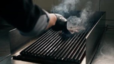 Bir otel restoranında profesyonel mutfak spatula sulu pastırmalı ızgara gıda hamburgeriyle kalkıyor.