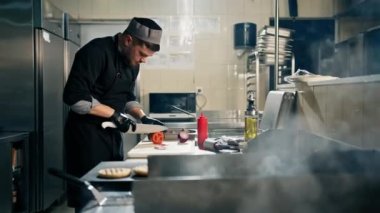 Otel restoranında profesyonel mutfak bıçaklı şef sebze burgeri keser.