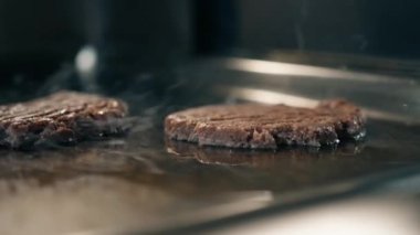 Profesyonel restoran mutfağı hamburgerler için ızgarada lezzetli köftelerin yakın plan çekimi.