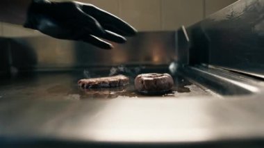 Restoranın mutfağında şef köfteleri ezmek için hazırlar ve köfteyi basınla ezer.