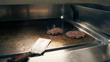 Profesyonel restoran mutfağı yakın çekim şefi spatula parçacıklı burgerli lezzetli köfteler yapıyor.