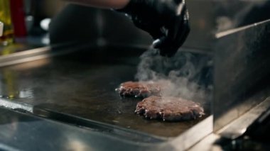 Profesyonel restoran mutfağı hamburgerler için ızgarada lezzetli köftelerin yakın plan çekimi.