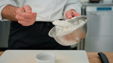 Profesyonel mutfak şefi ekşi krema sosu yapar fırında patatesle baharatları karıştırır.