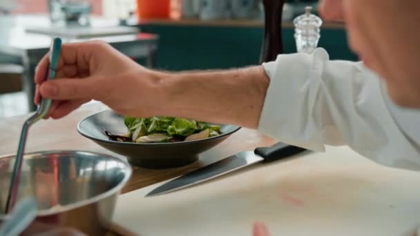 プロのキッチンシェフは 健康食品の成分を混合トングとプレート上の梨とチーズとサラダの葉を置きます — ストック動画