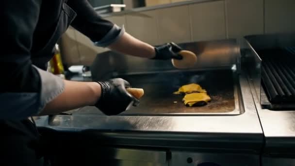 宾馆餐厅的专业厨房特写镜头粉碎汉堡肉饼包 用奶酪片烤 — 图库视频影像
