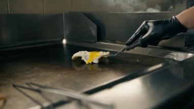 Otel restoranındaki profesyonel mutfakta şef fırında pişirmek için domuz pastırması ve tavuk filetosu hazırlar.