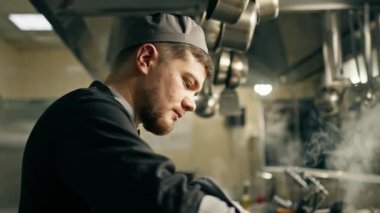 Otel restoranındaki profesyonel mutfak. Şef öğle yemeği için risotto hazırlıyor. Pirinç karıştırıyor.