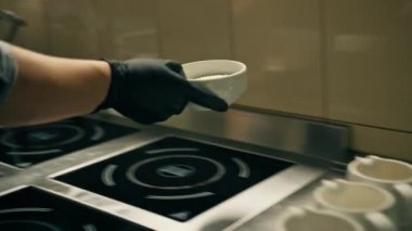 Otel restoranındaki profesyonel mutfak. Şef öğle yemeği için risotto hazırlıyor. Pirinç karıştırıyor.