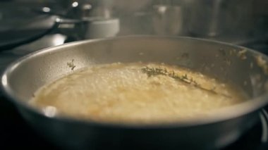 Otel restoranındaki profesyonel mutfak. Yakın plan lezzetli risotto tavada hazırlanıyor.