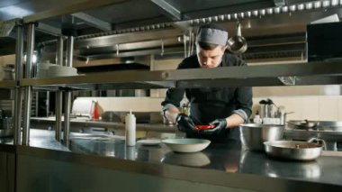 Otel restoranında profesyonel mutfak. Şef tabakta deniz ürünleri salatası için malzemeler hazırlıyor.