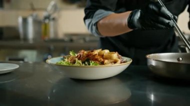 Otel restoranında profesyonel mutfak. Şef tabakta deniz ürünleri salatası için malzemeler hazırlıyor.