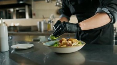Otel restoranında profesyonel mutfak. Şef tabakta deniz ürünleri salatası için malzemeler hazırlıyor.