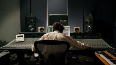 Ses mühendisi müzik stüdyosunda çalışıyor. Monitörler ve ekran karıştırma ve ana parçalarla.