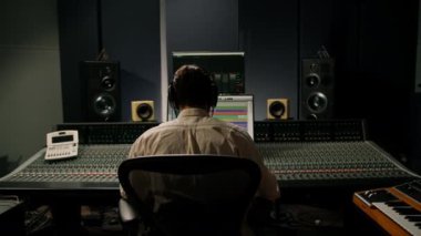 Ses mühendisi müzik stüdyosunda çalışıyor. Monitörler ve ekran karıştırma ve ana parçalarla.