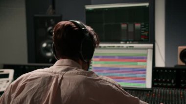 Ses mühendisi müzik stüdyosunda çalışıyor. Monitörler ve ekran karıştırma ve ana parçalarla.