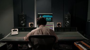 Ses mühendisi müzik stüdyosunda çalışıyor. Monitörler ve ekran karıştırma ve ana parçalarla.