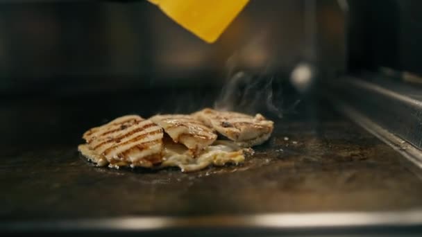 宾馆的专业厨房餐厅里有鸡蛋一片芝士熏肉和鸡肉在炉灶边近身煎 — 图库视频影像