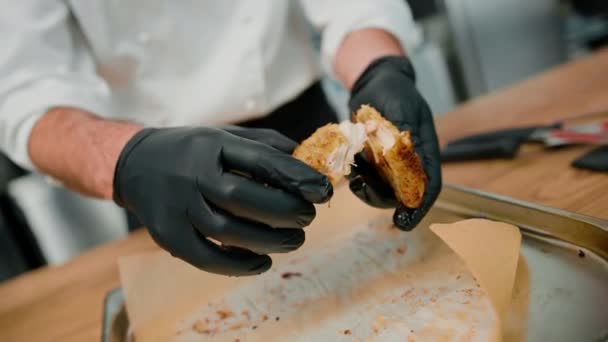 プロのキッチンのシェフがパンくずで焼いたチキンフィレを手で裂いて — ストック動画