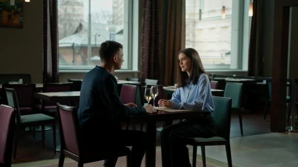 在宾馆餐厅里 一个男人和一个女人在一个微笑的女孩面前 戴着眼镜喝着白葡萄酒 — 图库视频影像