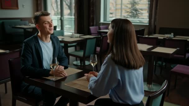 식당에서 남자와 여자가 소녀의 얼굴에 와인을 마시는 데이트 — 비디오