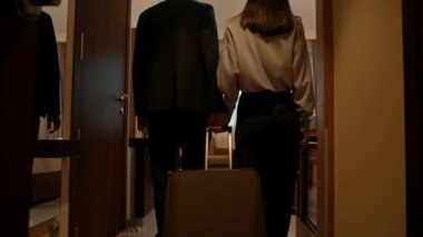 Bavullara aşık bir çift seyahat konsepti sırasında otel odalarına girer.