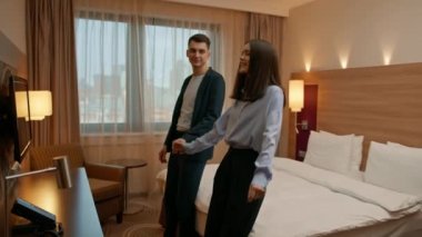 Yataktaki lüks otel odasındaki çift otel odasındaki yatakta uzanan romantik çift yakışıklı erkek ve kadın tatilin tadını çıkarıyor.