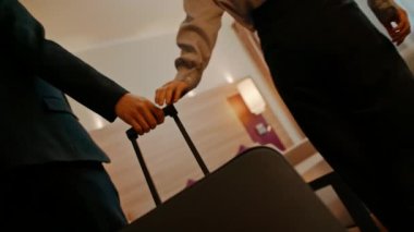 Elinde bavul olan bir adam, iş gezisi sırasında otel odasına geldi.