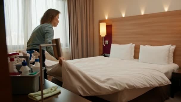 一位穿着制服的女管家准备了一张床 准备好豪华宾馆房间 供客人们清洁和旅行 — 图库视频影像