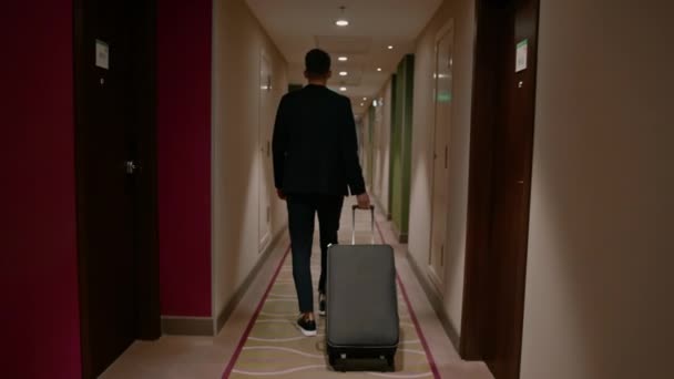 Ein Mann Mit Einem Koffer Läuft Den Hotelflur Hinunter Eine — Stockvideo