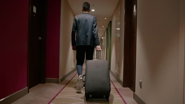 Ein Mann Mit Einem Koffer Läuft Den Hotelflur Hinunter Eine — Stockvideo