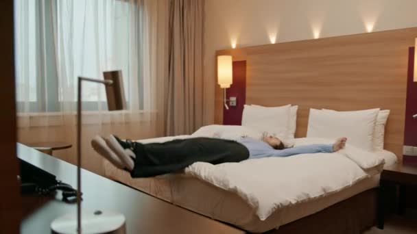 快乐美丽的女孩躺在豪华酒店房间里 在旅行中休息 — 图库视频影像