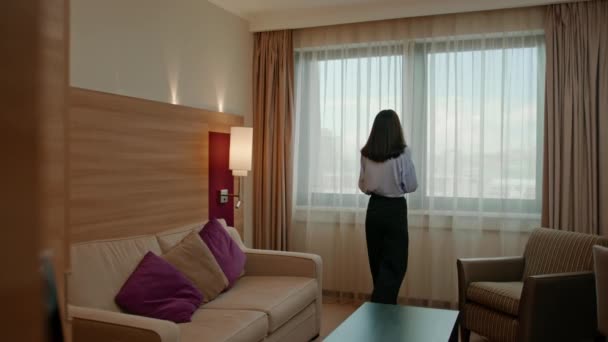 Młoda Kobieta Otwierając Zasłonę Stojąc Luksusowy Pokój Hotelowy Patrząc Przez — Wideo stockowe