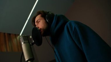 Kulaklıklı rap şarkıcısı. Profesyonel kayıt stüdyosunda duygusal olarak yeni şarkı kaydediyor.