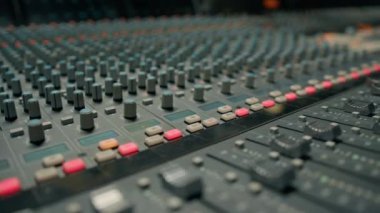 Faders 'ı ayarlayan mikser konsolunun yakın çekimi. Profesyonel kayıt stüdyosunda çalışan bir ses mühendisi.