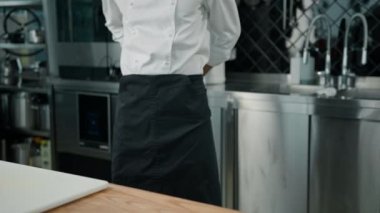 Profesyonel mutfak şefi, restoran ve mutfak konseptine başlamadan önce üniforma bağlıyor.