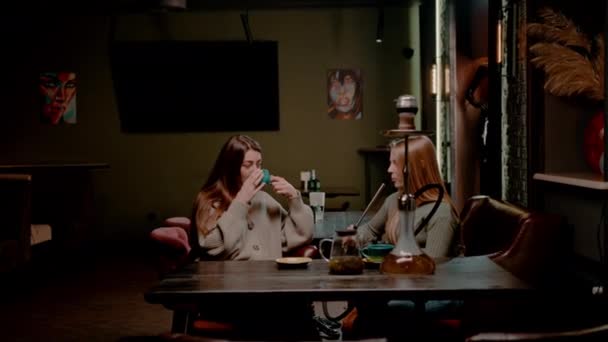 Δύο Νεαρές Φίλες Κάθονται Χαλαρές Στο Μπαρ Hookah Καπνίζοντας Hookah — Αρχείο Βίντεο