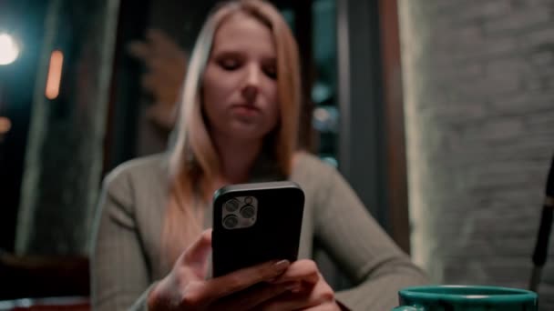 お茶と電話を手に若い女の子がフックバーでリラックスし 誰かのレクリエーションのコンセプトでテキストメッセージを閉じる — ストック動画